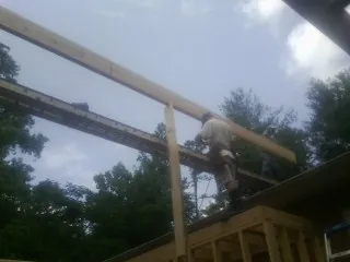 Carpenter setting a ridge beam over a new addition frame — Ice Dam Removal by Roofing Brothers in Leeton